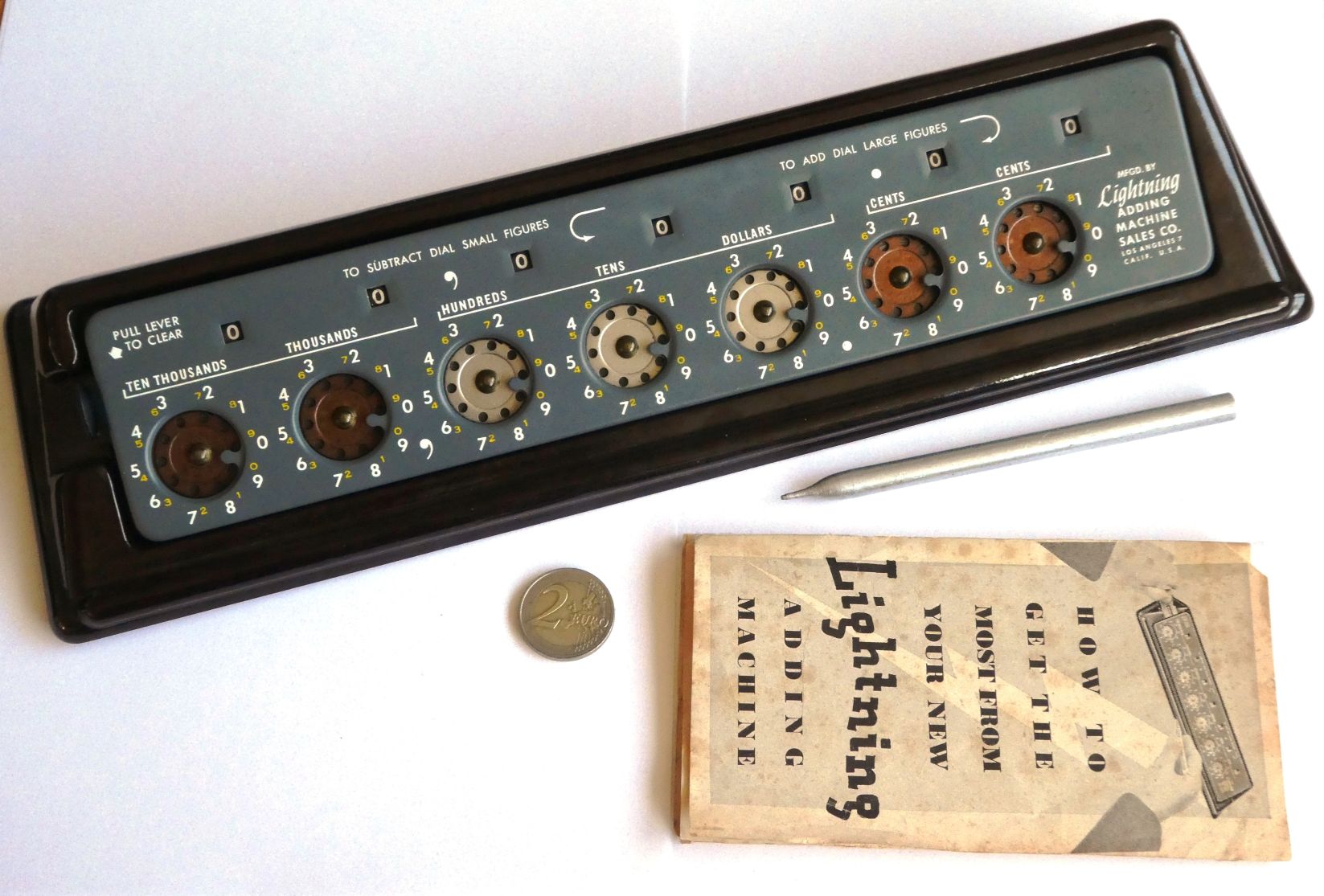 Figure 13 — The final form: a grey subtracting Lightning of the Sales Co. with the clearing tab at the left, large white figures for adding and small yellow figures for subtracting, in its brown Bakelite stand…