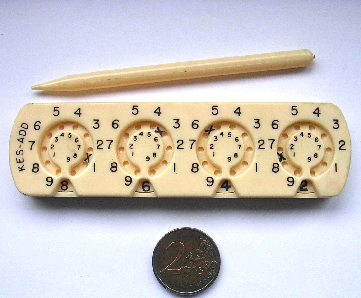 Figure 11 — The Kesling Pocket Adder (Kes-Add): four plastic dials, with small reversed figures for subtraction, and its plastic stylus.