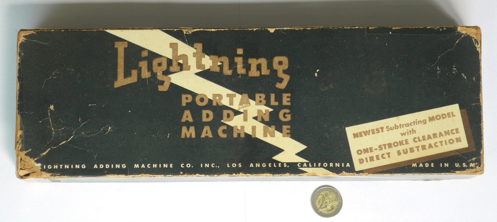 Figure 3 — A Lightning box: "Lightning Portable Adding Machine", with an end label for the "newest subtracting model" with one-stroke clearance and direct subtraction.