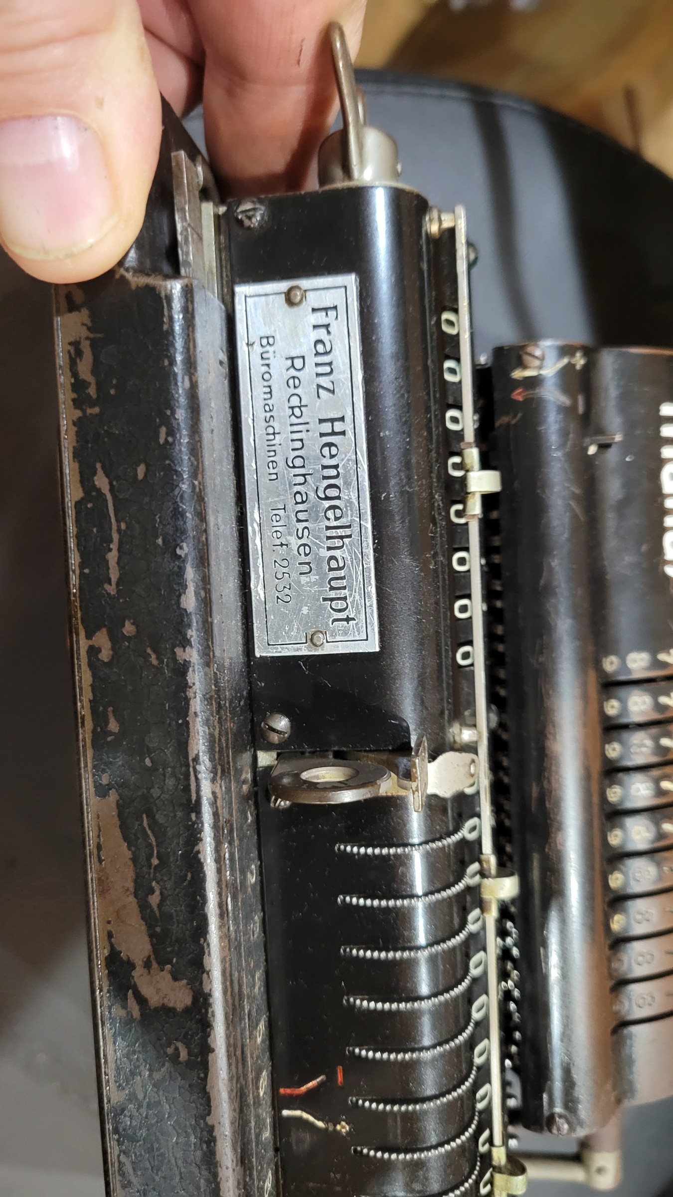 Figure 3 — The left end of my Manus with the dealer's plate of Franz Hengelhaupt, office machines, Recklinghausen, telephone 2532. The counter windows and the knurled counter wheels are to its right.