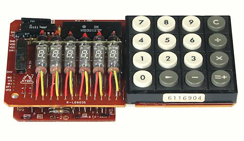 Figure 6 — Inside a Casio Mini of 1972: six single-digit fluorescent tubes on their leads, and the Hitachi HD32127 that did all the calculating.