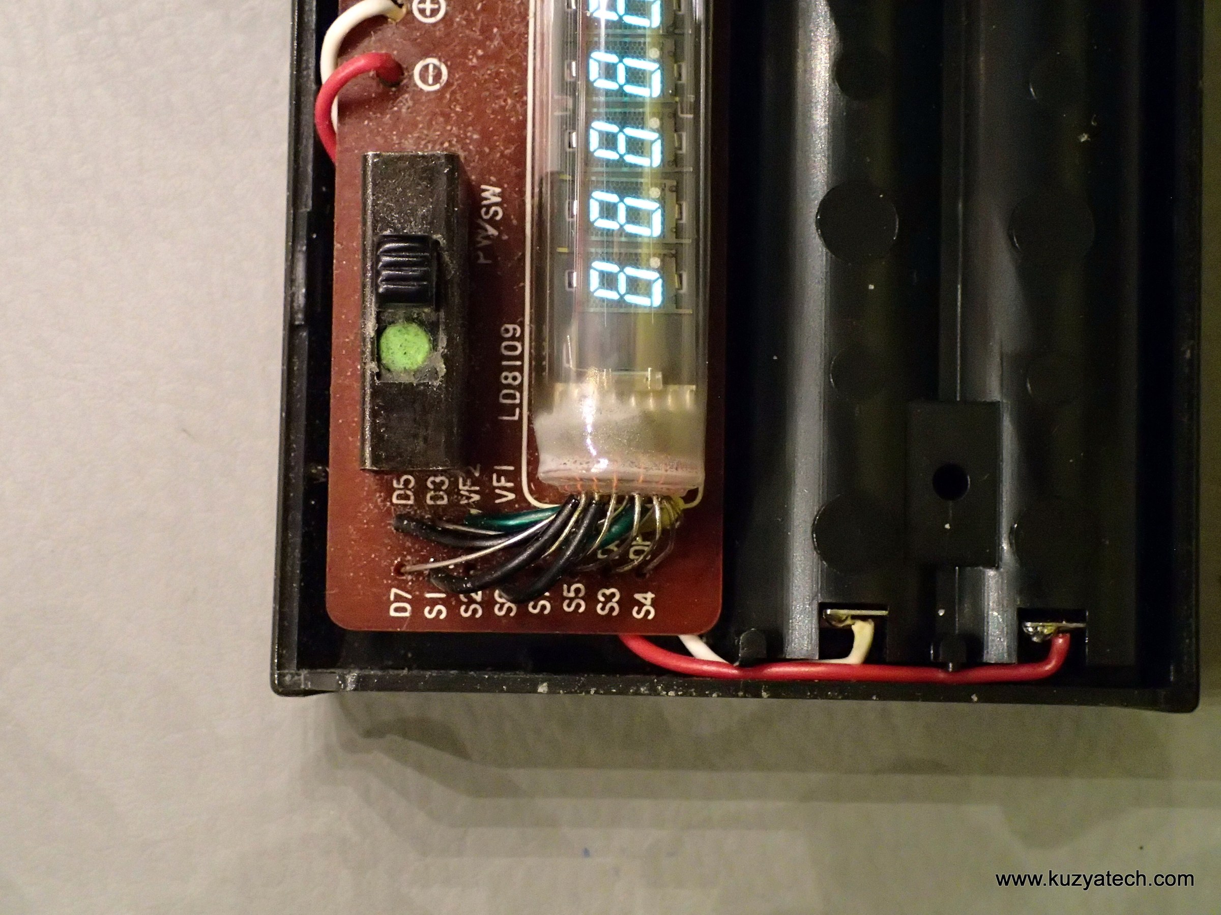 Figure 2 — The end of a Casio Personal-mini's board: the multi-digit tube with its flying leads, beside the battery holder whose contacts are the first thing to check in any pocket machine.